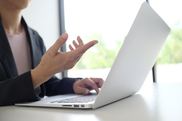 Homem trabalhando usando um laptop na mesa de madeira Mãos digitando em um teclado