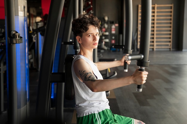 Foto homem trans se exercitando na academia