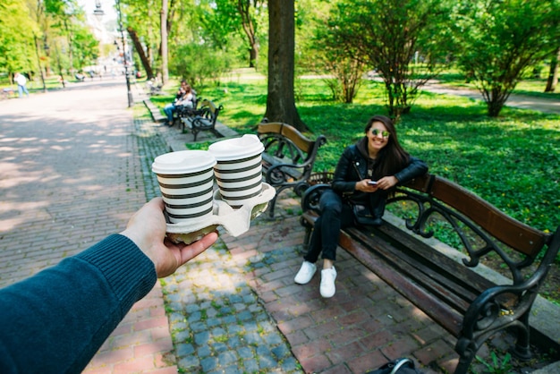 Homem traz café para um encontro de jovem no parque da cidade