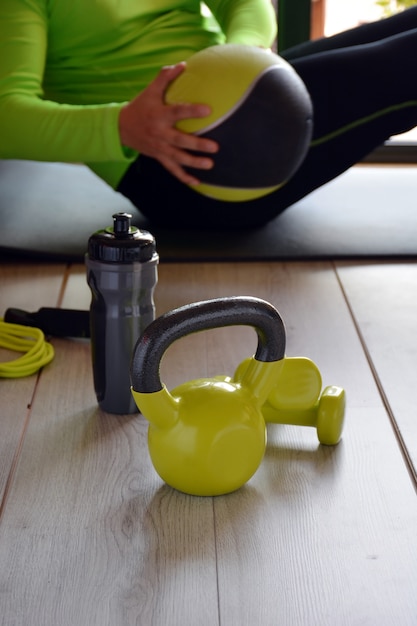 Homem treinando com kettlebell e medicine ball em casa