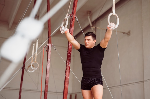 Foto homem treinando em argolas de ginástica