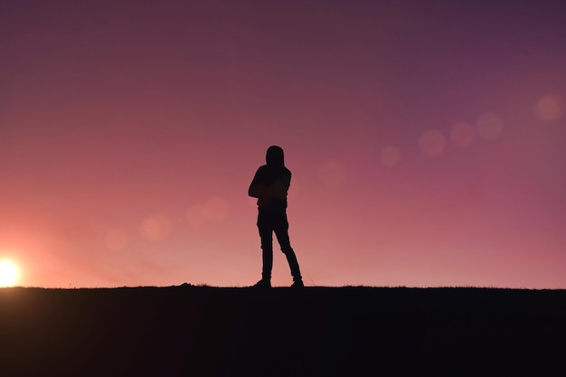 homem trekking na montanha com um fundo por do sol no verão