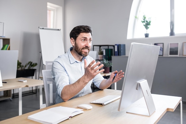 Homem triste e ansioso trabalhando no empresário do escritório frustrado com o resultado do trabalho cansado e deprimido olhando para a tela do monitor