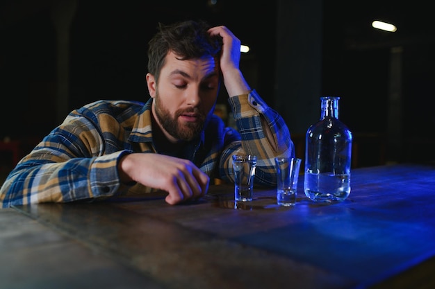 Foto homem triste sentado no bar contra o vício em álcool