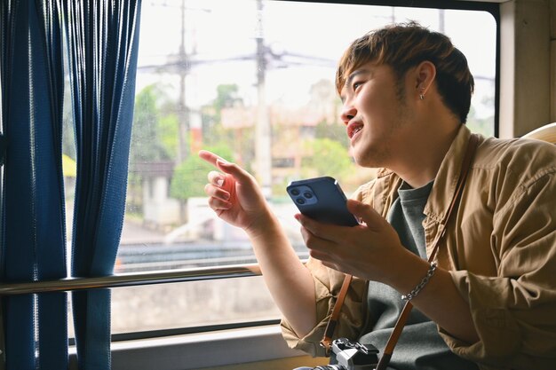 Foto homem turista feliz olhando pela janela enquanto se desloca de ônibus