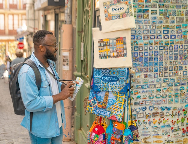Homem turista olhando as lembranças no mercado do Porto