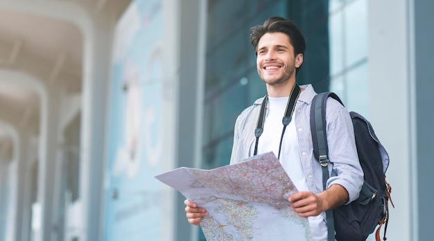 Homem turista procurando rota no mapa no aeroporto