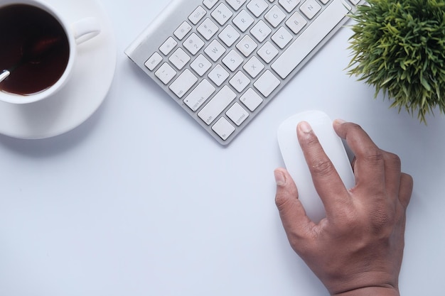 Homem usa o mouse do computador em fundo branco