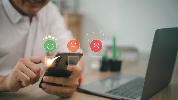 Homem usa smartphone escolhendo avaliação de feedback de ícone de rosto de sorriso feliz verde e experiência de avaliação positiva do cliente pesquisa de satisfação avaliação de saúde mental conceito de dia mundial da saúde mental