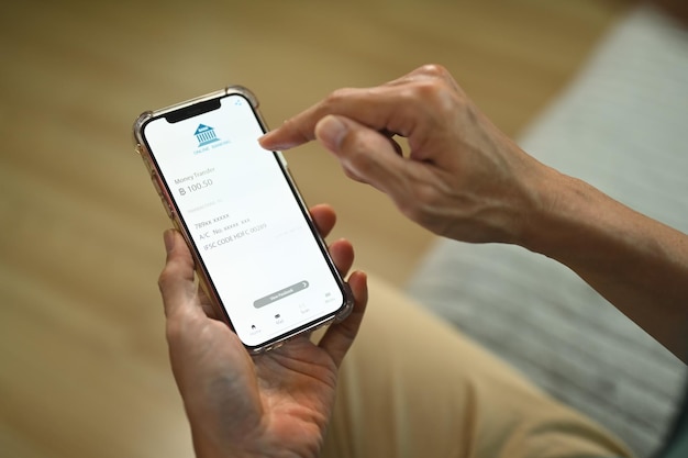 Homem usando aplicativo bancário em smartphone para pagamento e contabilidade sem contato