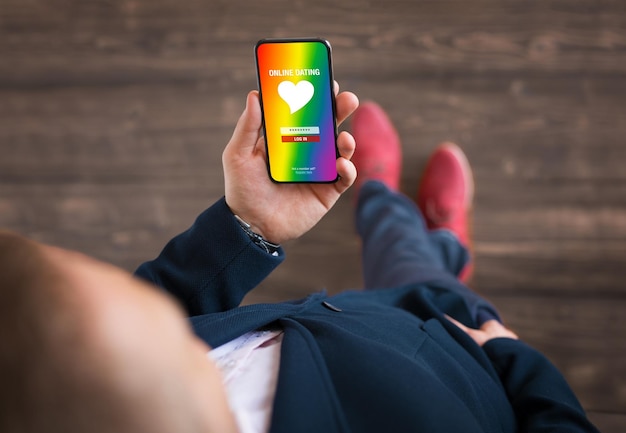 Homem usando aplicativo de namoro da comunidade gay e LGBT em seu celular