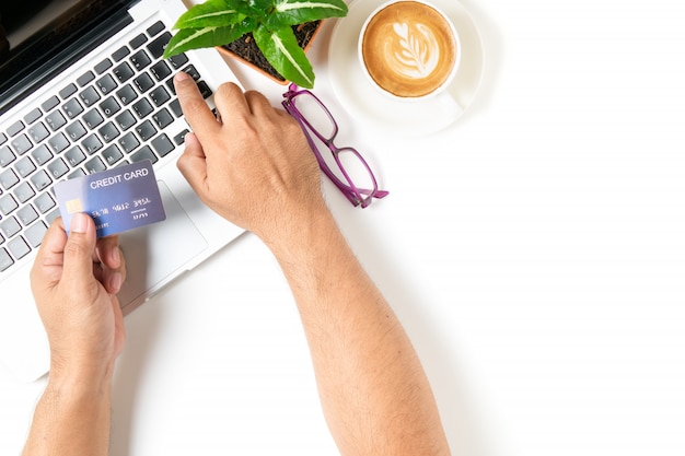 Homem usando cartão de crédito para compras on-line com café quente com leite latte art isolado no fundo branco