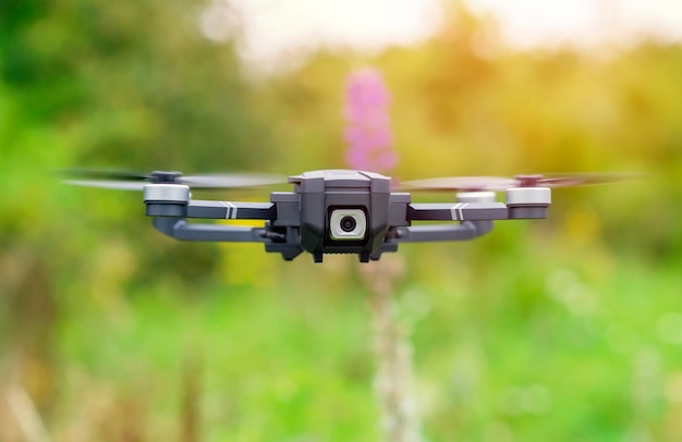 Homem usando drone com controle remoto fazendo fotos e vídeos se divertindo com a nova tecnologia