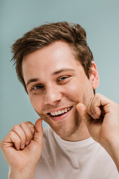 Homem usando fio dental