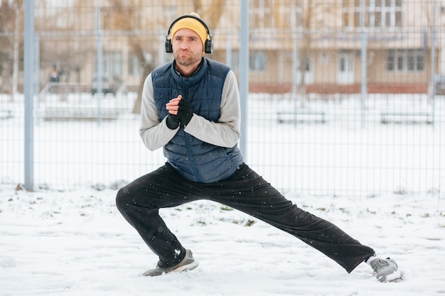 Homem usando fone de ouvido praticando ginástica no inverno