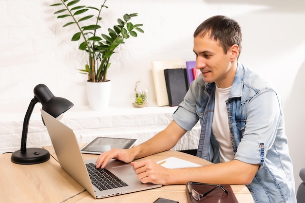 Homem usando laptop na mesa em casa