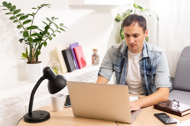 Homem usando laptop na mesa em casa