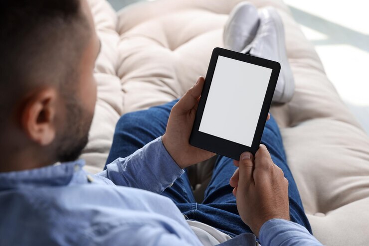 Foto homem usando leitor de ebook no sofá dentro de casa closeup