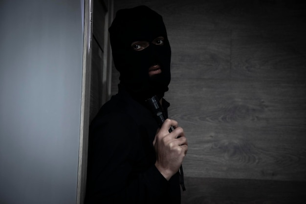 Foto homem usando máscara no apartamento à noite com lanterna
