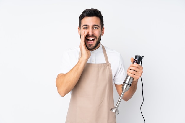 Homem usando o liquidificador isolado na parede branca, gritando com a boca aberta