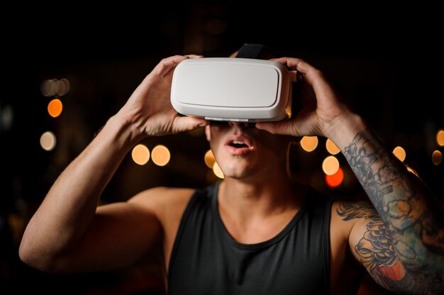 Homem usando óculos VR fone de ouvido 3D deliciosamente olhando para cima com a boca aberta