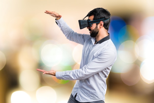 Homem usando óculos VR segurando algo no fundo não focado