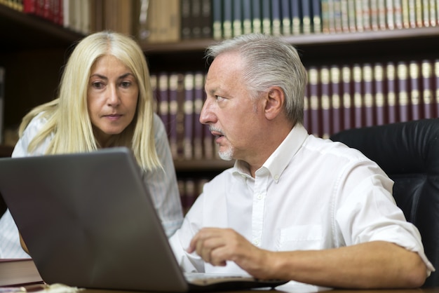 Homem usando seu laptop enquanto conversava com uma mulher