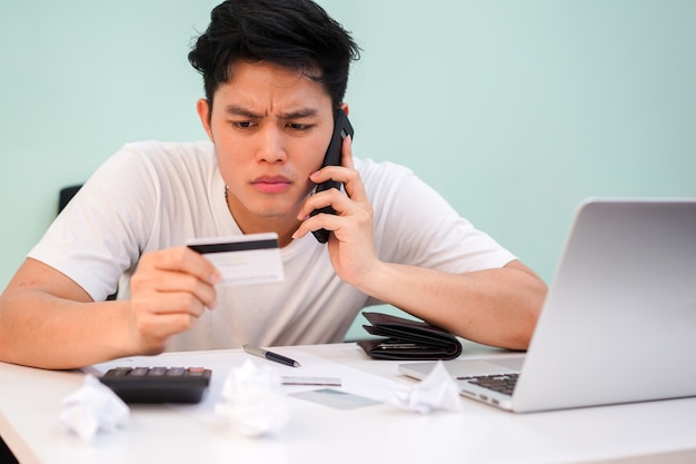 homem usando smartphone para ligar para falar com o operador bancário para perguntar sobre pagamento