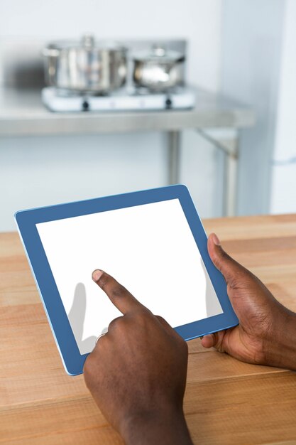 Homem usando tablet digital na cozinha em casa