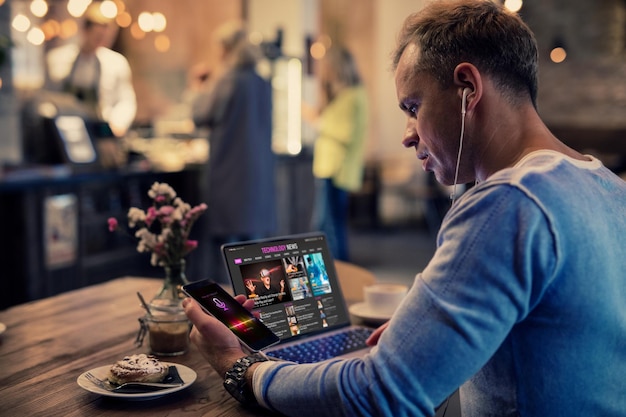 Homem usando tecnologia moderna enquanto está sentado no café