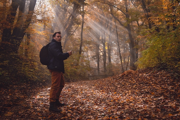 Homem usando telefone na floresta