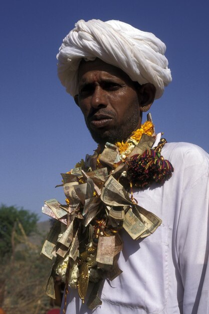Foto homem usando um colar feito de papel moeda