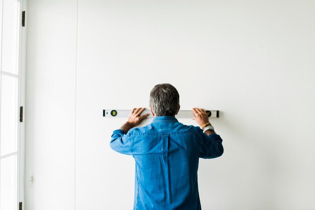 Homem, usando, um, nível espírito, ligado, um, parede