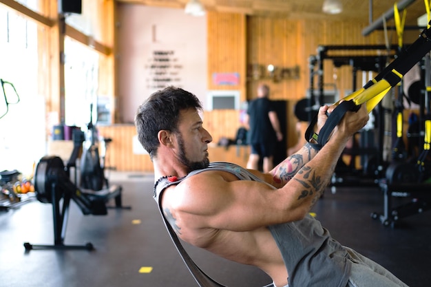 Homem usando um trx em uma academia