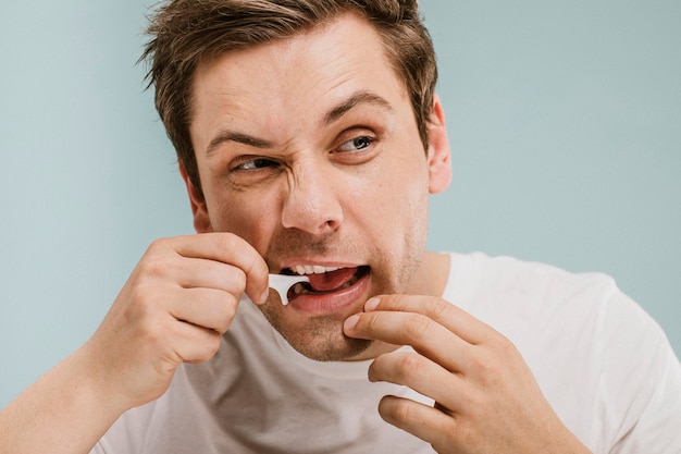 Homem usando uma picareta de fio dental