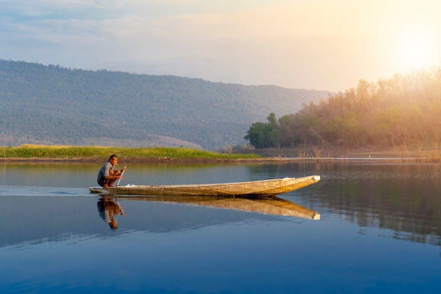 Homem velho, pesca, sentando, barco madeira homem tailandês, remando, um, barco, ligado, lago