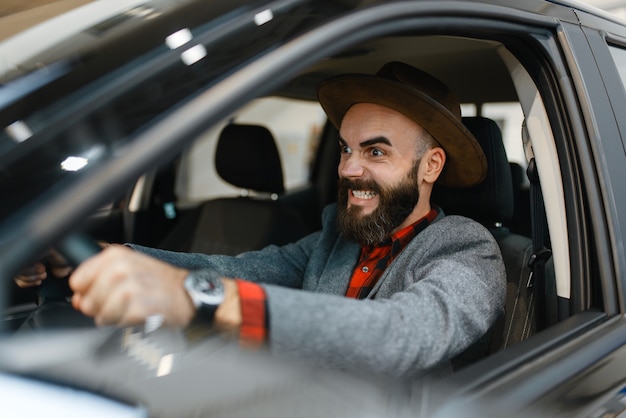 Homem verifica o interior da nova caminhonete na concessionária. cliente no showroom de veículos, homem comprando transporte, concessionária de automóveis