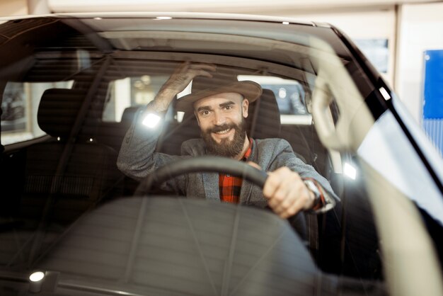 Homem verifica o interior da nova caminhonete na concessionária. cliente no showroom de veículos, homem comprando transporte, concessionária de automóveis