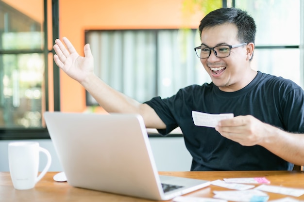 Homem verificando os resultados da loteria no laptop e ganhando