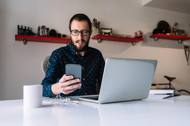 Foto homem verificando seu telefone durante o teletrabalho