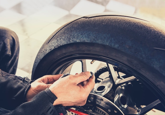 homem, verificar, pressão ar, de, roda motocicleta, antes de, viajando