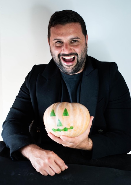 Homem vestido para o halloween com uma abóbora na mão.