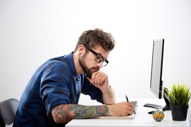 Homem vestindo camisa azul sentado com laptop, conceito freelance, retrato, trabalho online, processo de trabalho, excesso de trabalho.