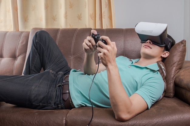 Homem vestindo óculos de realidade virtual assistindo filmes ou jogando videogames. O design do auricular vr é genérico e não possui logotipos.