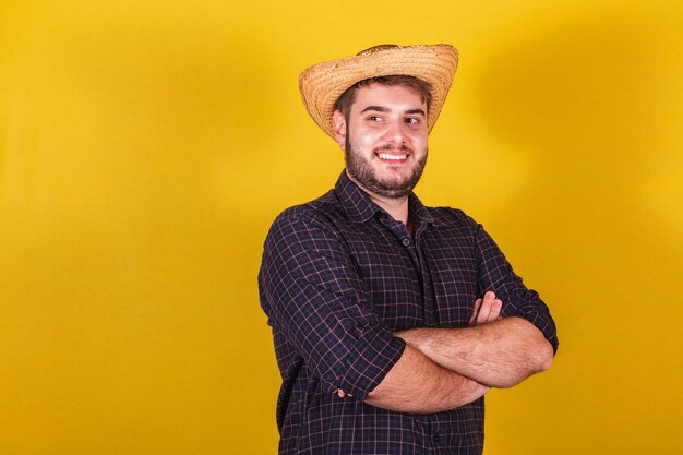 Homem vestindo roupas típicas para Festa Junina Festa de Arraia de São João com os braços cruzados