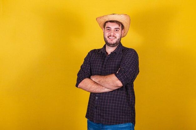 Homem vestindo roupas típicas para Festa Junina Festa de Arraia de São João com os braços cruzados