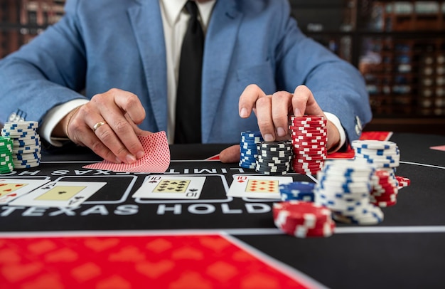 homem vestindo terno jogando poker na mesa do cassino ganhando Royal Flush no cassino conceito de jogo