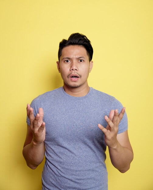 Homem vestindo uma camiseta casual fala expressão olhando para a câmera isolada em um fundo de cor amarela