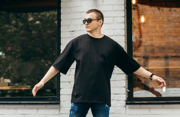 Homem vestindo uma camiseta preta em branco com espaço para seu logotipo ou desenho. Simulação