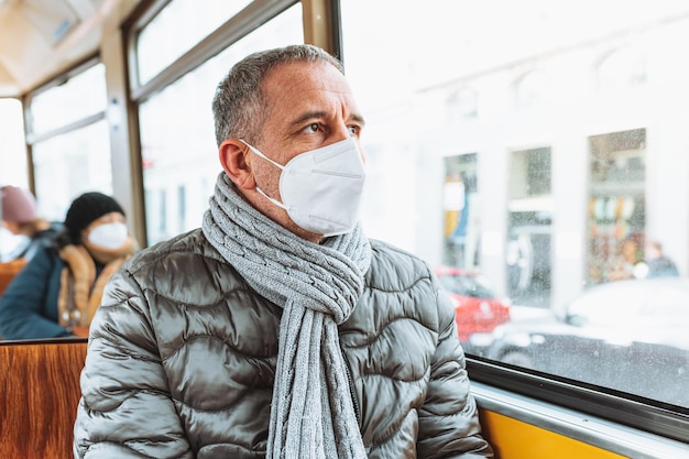 Homem vestindo uma máscara em um ônibus